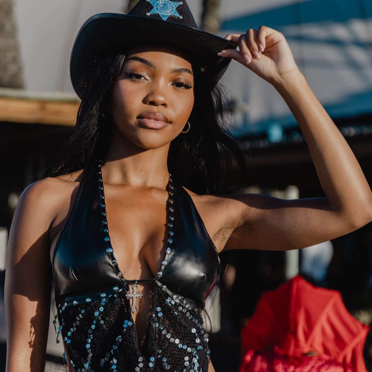 A festival-goer in a black cowboy hat and sequined top
