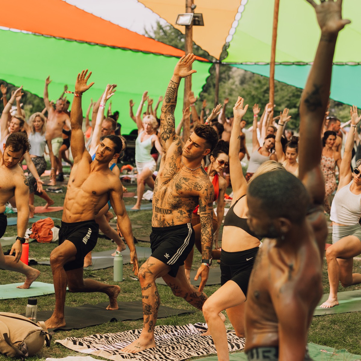 A crowd stretching together during a daytime movement session